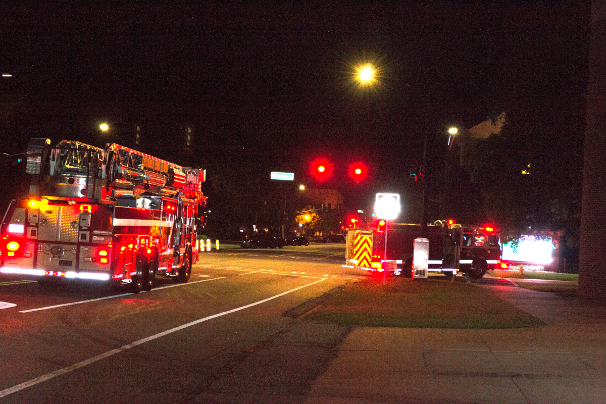 Two Fire Trucks Drivint at Night with Lights On